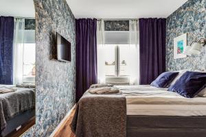 a bedroom with two beds and purple curtains at Hotell Nordevik in Skärhamn