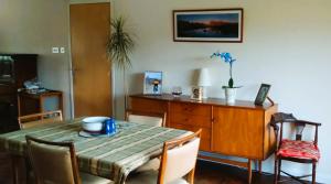 a dining room with a table with chairs and a dresser at Aquila Retreats in Comrie