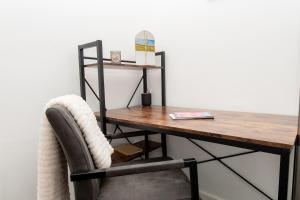 a desk with a chair and a wooden table at Modern 1 bed flat on the outskirts of Kingston in Teddington