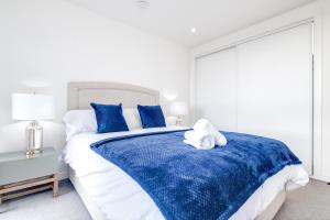 um quarto com uma cama azul e branca com almofadas azuis em Broadway Mailbox Luxury New 1 Bed Apartment with Free Parking em Birmingham