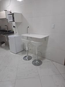 a white kitchen with a sink and a counter at POUSADA FLAT MÃE RAINHA in Maceió