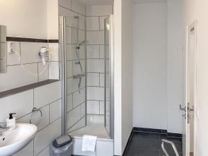 La salle de bains est pourvue d'une douche et d'un lavabo. dans l'établissement Hotel Hervest, à Dorsten