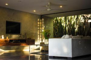 a living room with a white couch and a tv at Wahyu Private Peaceful Two Br Rustic Villa W Pool in Seminyak