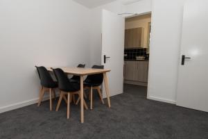 a table and chairs in a room with a kitchen at Modern 1 bed flat on the outskirts of Kingston in Teddington