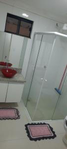 a bathroom with a shower and a red bowl on a counter at VS HOSPEDAGEM in Cascavel