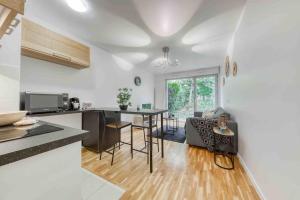 eine Küche und ein Wohnzimmer mit einem Tisch und Stühlen in der Unterkunft Appartement moderne, Metro 7, Parking et Jardin in Villejuif