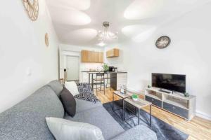 sala de estar con sofá gris y cocina en Appartement moderne, Metro 7, Parking et Jardin, en Villejuif 23 fotos más