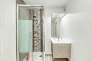 ein Bad mit einer Dusche und einem Waschbecken in der Unterkunft Appartement moderne, Metro 7, Parking et Jardin in Villejuif