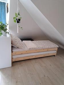 a small bed in a room with a staircase at Apartman Barbara in Lipany