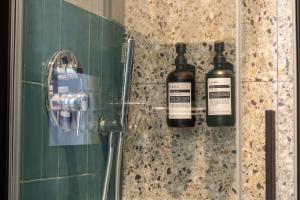 two bottles of wine on the wall of a shower at Cunabu Apartments in Rome