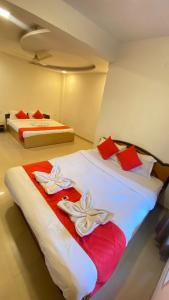 two beds in a room with red and white towels at The Forest World in Mahabaleshwar