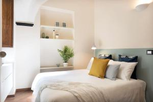 una camera da letto con un grande letto bianco con cuscini gialli di Alassio Vayadu' Arabesque ad Alassio