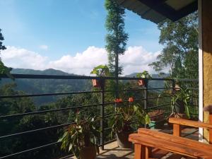 a balcony with a bench and a view of the mountains at NETHSARA cottage in Ella