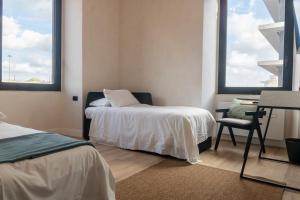 a bedroom with a bed and a desk and two windows at Cunabu Apartments in Rome