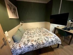 een slaapkamer met een bed en een bureau met een computer bij Émeraude - Centre-ville /Terrasse /Parking gratuit in Roanne