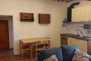 eine Küche mit einem Tisch, einem Tisch und einem Sofa in der Unterkunft piccolo appartamento in Monticiano