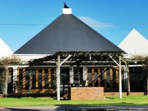 a black roofed building with a cross on top at Tortoise Trail Lodge in Langebaan
