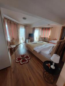a bedroom with a large bed and a wooden floor at Casa Tamara in Bran