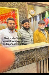 a group of three men standing behind a counter at Hotel Heaven View - 50m From Golden Temple in Amritsar