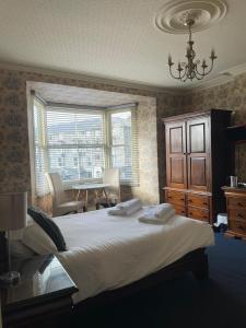 a bedroom with a bed and a table and a window at Tal Y Don Hotel in Barmouth