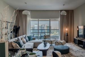 a living room with a couch and a table at Clever Guest Concorde JLT in Dubai