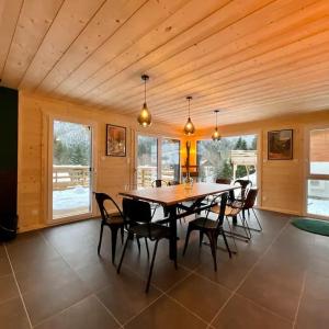 une salle à manger avec une table et des chaises en bois dans l'établissement CHALET LES 2 MARMOTTES 4 étoiles Bain nordique, Pétanque, à Gerbépal