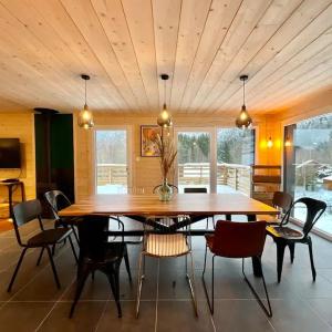 une salle à manger avec une grande table et des chaises en bois dans l'établissement CHALET LES 2 MARMOTTES 4 étoiles Bain nordique, Pétanque, à Gerbépal