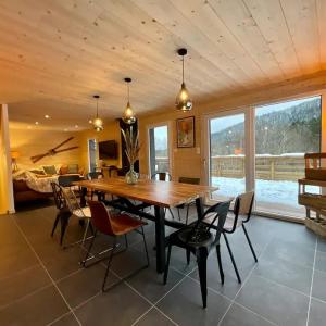 une salle à manger avec une table et des chaises en bois dans l'établissement CHALET LES 2 MARMOTTES 4 étoiles Bain nordique, Pétanque, à Gerbépal