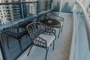 a balcony with four chairs and a table on a balcony at Clever Guest Concorde JLT in Dubai