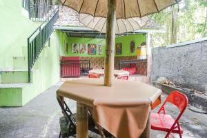 a table and chairs with an umbrella in a room at Green View Ubud Hostel Bali in Ubud