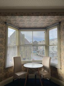 a table and two chairs in front of a window at Tal Y Don Hotel in Barmouth