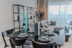 a dining room with a black table and chairs at Clever Guest Concorde JLT in Dubai