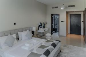 a bedroom with a large white bed and a desk at Clever Guest Concorde JLT in Dubai +27 photos