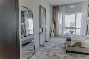 a white bedroom with a bed and a mirror at Clever Guest Concorde JLT in Dubai