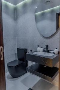 a bathroom with a black toilet and a sink at Clever Guest Concorde JLT in Dubai