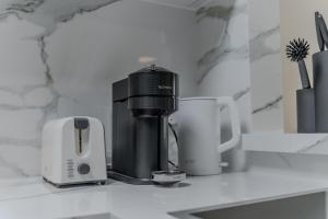 a coffee maker and two cups on a counter at Clever Guest Concorde JLT in Dubai