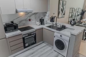 a kitchen with a sink and a washing machine at Clever Guest Concorde JLT in Dubai