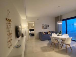 a living room with a table and a blue couch at Corte Cesarina in Porto Cesareo