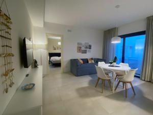 a living room with a table and a blue couch at Corte Cesarina in Porto Cesareo
