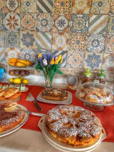 una mesa con pasteles y otros alimentos en ella en Ciriga Sicily Glamping Resort, en Santa Maria del Focallo
