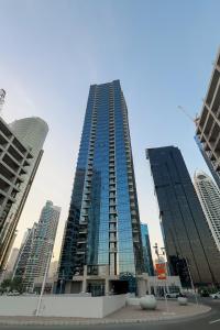 a tall building with glass windows in a city at Clever Guest Concorde JLT in Dubai