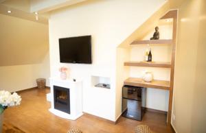 a living room with a fireplace and a flat screen tv at Vier Jahreszeiten Suite mit Whirlpool Badewanne L Vazzano in Husum