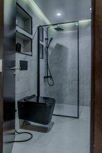 a bathroom with a black toilet and a shower at Clever Guest Concorde JLT in Dubai