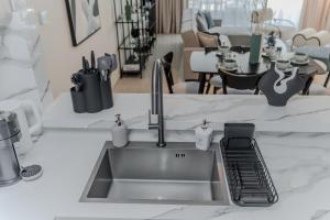a kitchen sink with a faucet on a counter at Clever Guest Concorde JLT in Dubai
