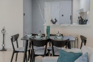 a dining room with a table and chairs and a kitchen at Clever Guest Concorde JLT in Dubai