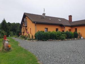 a house with a gravel driveway in front of it at Agroturystyka Świerki in Lubawka