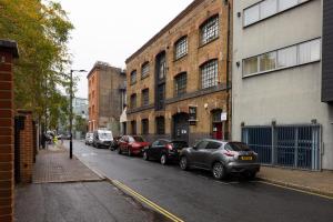a row of cars parked on a street next to buildings at Do not use in London