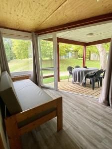 Habitación con cama y mesa en la terraza. en Camping maeva Respire Le Moulin de Surier, en Beaumont-du-Périgord