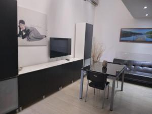salon ze stołem i telewizorem w obiekcie Bunker degli inventori w mieście Foggia