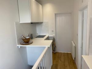 a kitchen with white cabinets and a counter top at The Studio in Frinton-on-Sea